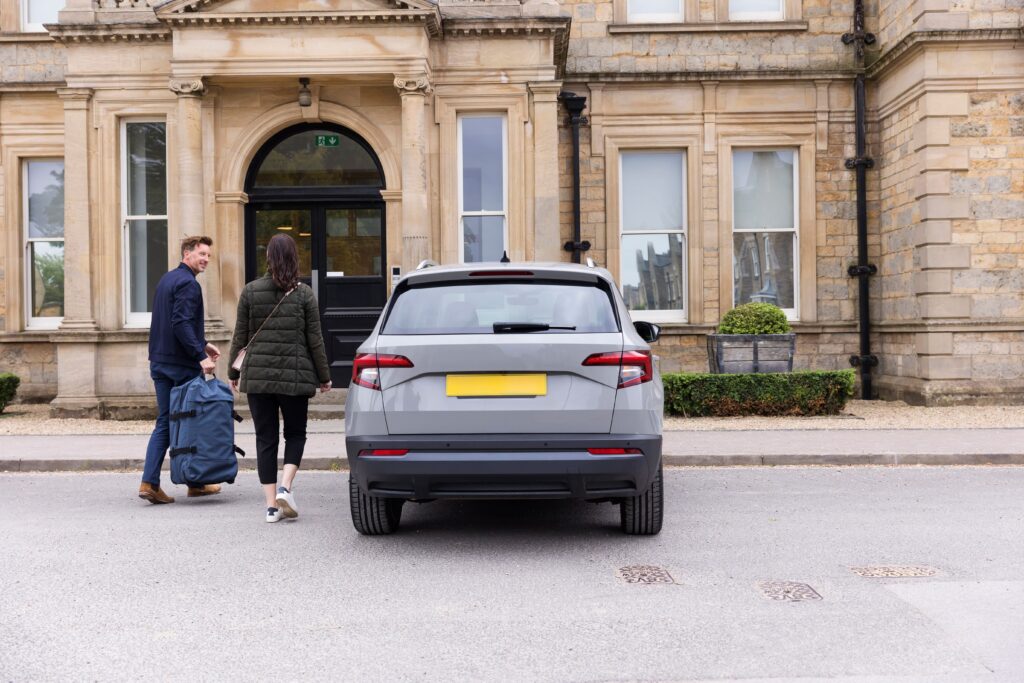 Two people walking up to a car